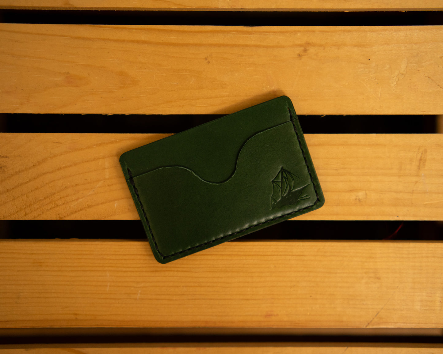 Green horizontal leather wallet with three pockets.