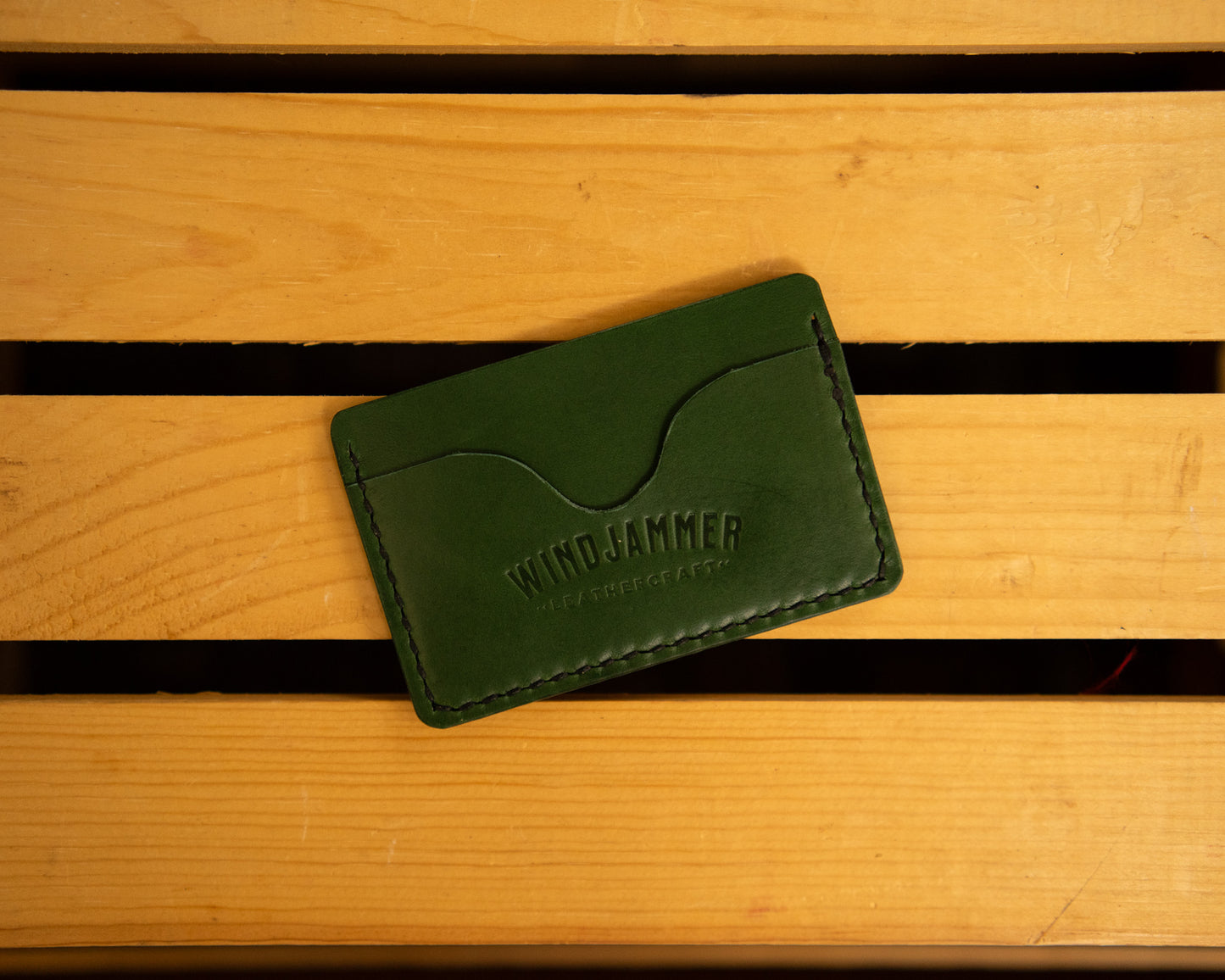 Green horizontal leather wallet with three pockets.