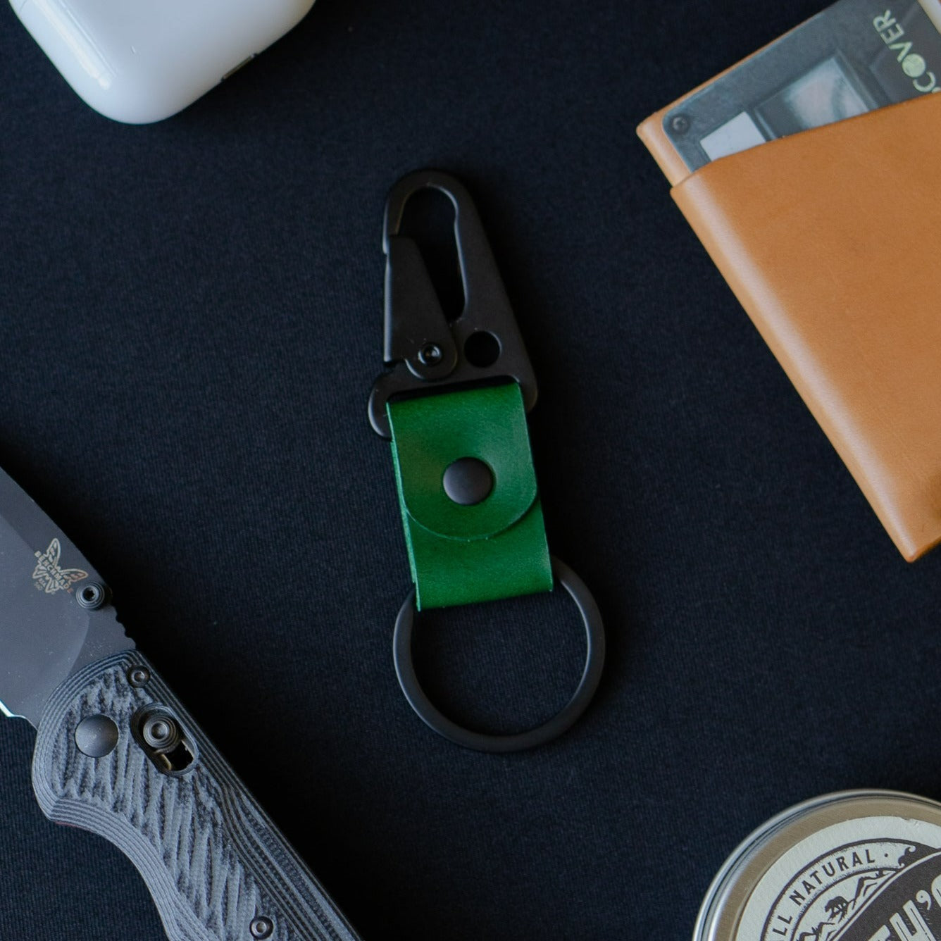 Green leather keychain surrounded by products